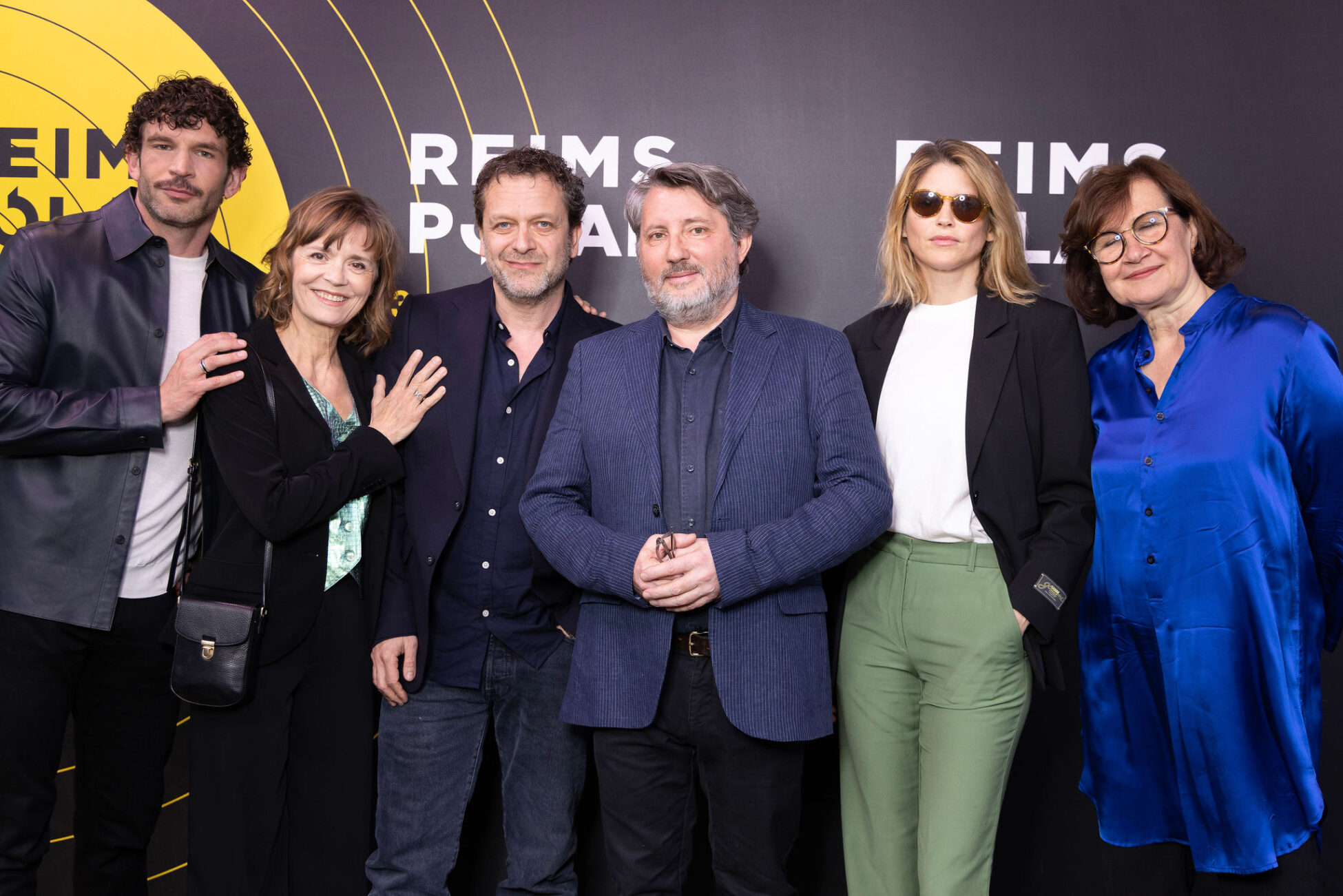 Group of six people posing in front of Reims Polar Festival backdrop during event
