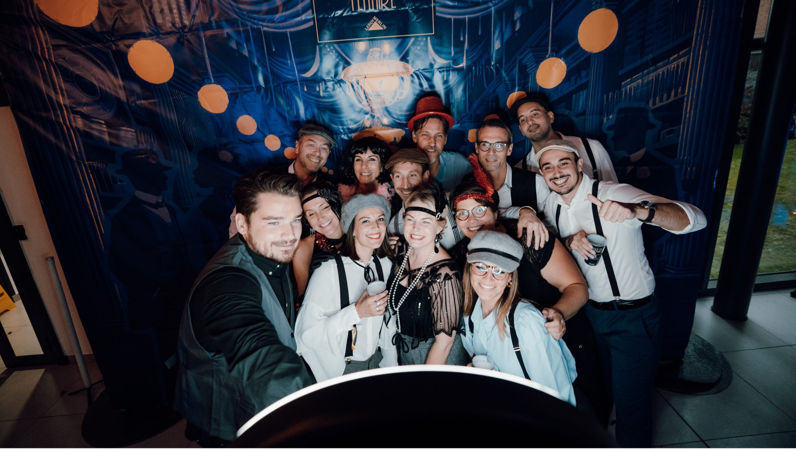 Group of people dressed in vintage-inspired costumes smiling and posing together indoors