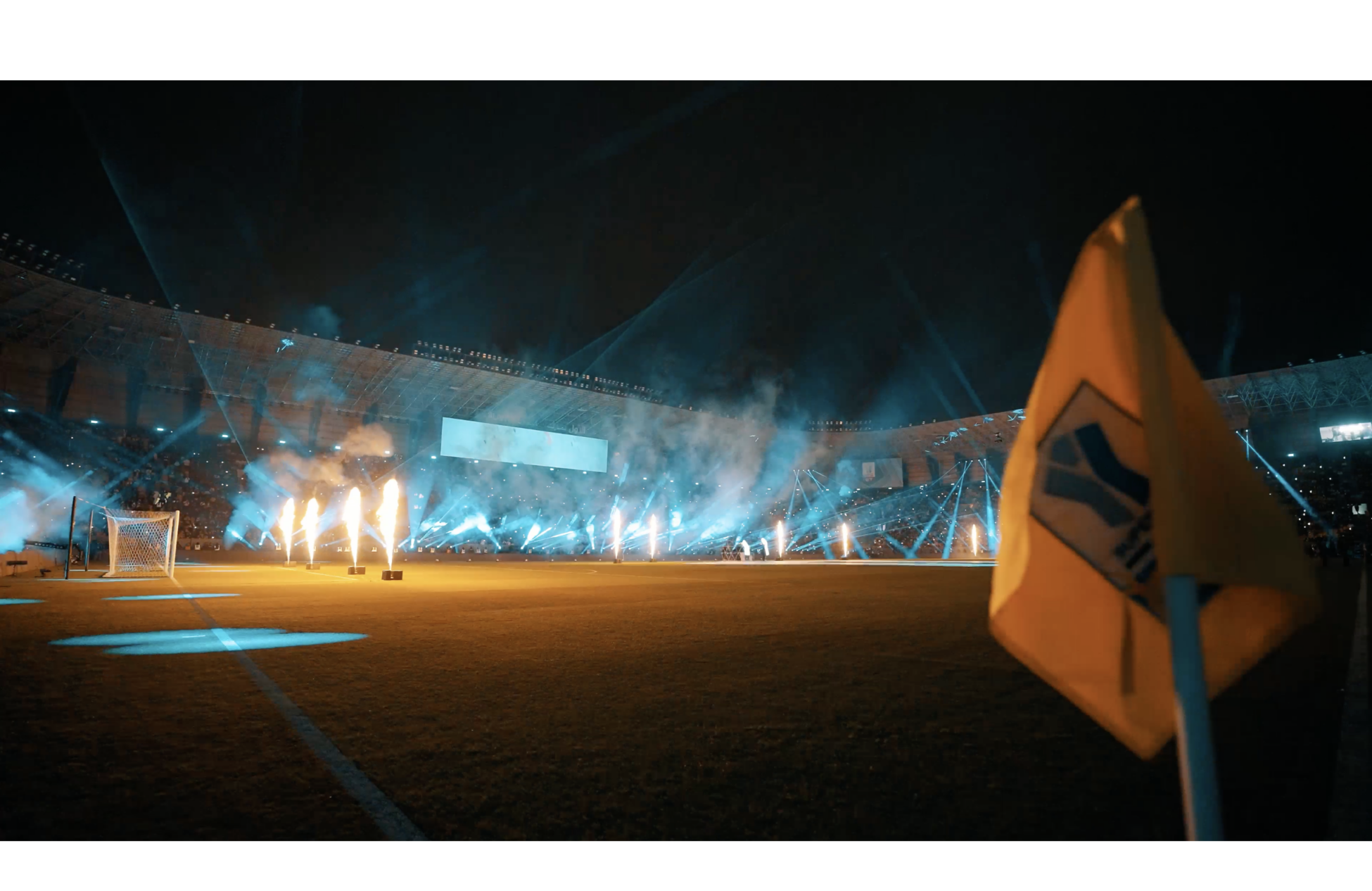ceremony at a stadium at night with fire and lightshow